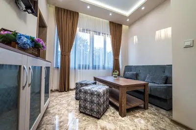 a living room with a couch and a table at Слънчевите Къщи in Banya