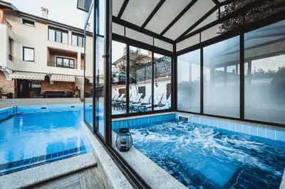 a swimming pool with a view of a building at Слънчевите Къщи in Banya