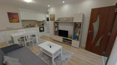 a living room with a couch and a table and a kitchen at White grapes apartment in Petrich