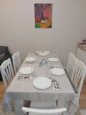 a white table with white plates on it at White grapes apartment in Petrich