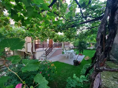a garden with a table and chairs in a yard at White grapes apartment in Petrich