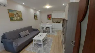 a living room with a couch and a table at White grapes apartment in Petrich