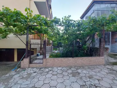 a fence with trees in front of a building at White grapes apartment in Petrich