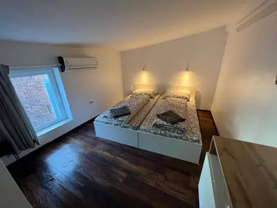 a bedroom with a bed with two pillows and a window at The rainbow 4 in Sofia