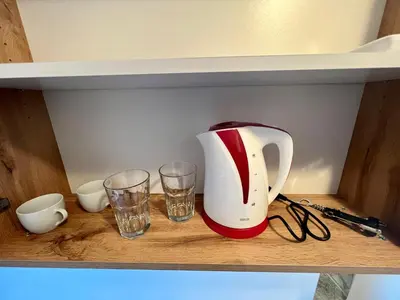 a tea kettle and two glasses on a shelf at The rainbow 4 in Sofia