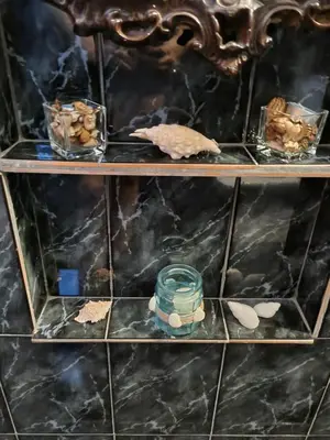 a shelf with three tiers of rocks and a candle at Tsar Simeon, 2 bedroom, living room and fireplace in Sofia