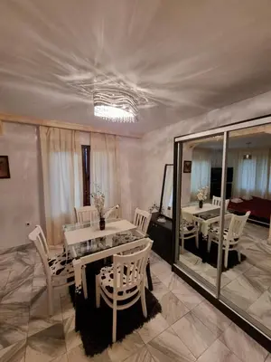 a dining room with white chairs and a table and mirrors at Tsar Simeon, 2 bedroom, living room and fireplace in Sofia