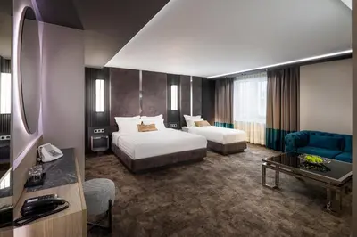a hotel room with a bedroom with a bed and a couch at -- ESTE PARK HOTEL -- part of Urban Chic Luxury Design Hotels - Parking & Compliments - next to Shopping & Dining Mall Plovdiv in Plovdiv