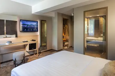 a bedroom with a bed and a desk and a bathroom at -- ESTE PARK HOTEL -- part of Urban Chic Luxury Design Hotels - Parking & Compliments - next to Shopping & Dining Mall Plovdiv in Plovdiv