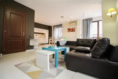 a living room with a black couch and a table at Trendy & Deluxe Apartment by Flat Mаnager in Plovdiv