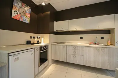 a kitchen with white cabinets and a clock on the wall at Trendy & Deluxe Apartment by Flat Mаnager in Plovdiv