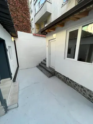 an empty courtyard of a house with a white wall at The rainbow 6 in Sofia