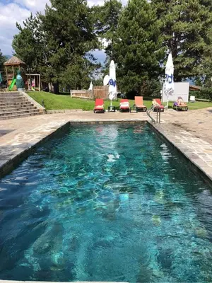 a large swimming pool with chairs and umbrellas at Allure in Pirin Golf in Razlog