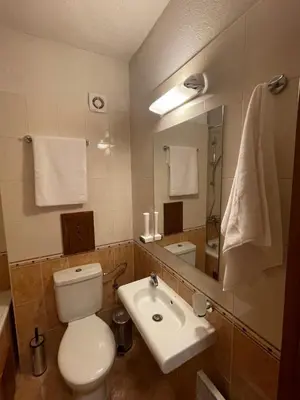 a bathroom with a toilet and a sink and a mirror at Allure in Pirin Golf in Razlog