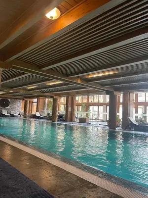 a swimming pool with blue water in a building at Allure in Pirin Golf in Razlog