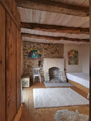 a living room with a stone fireplace and a couch at Вила 'Гнездото', Villa 'The nest', Rhodope mountains, Banite in Vishnevo