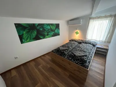 a bedroom with a bed and a large painting on the wall at The rainbow 7 in Sofia