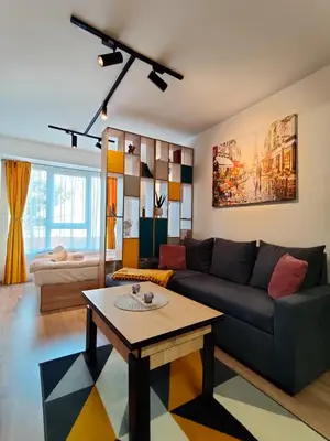 a living room with a couch and a table at Cozy Studio near the Historical Heart of Sofia by Flat Mаnager in Sofia