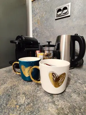 two coffee mugs sitting on top of a counter at Cozy Studio near the Historical Heart of Sofia by Flat Mаnager in Sofia
