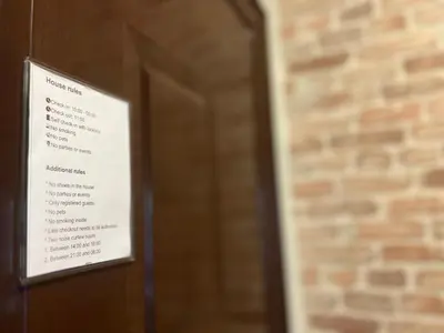 a sign on a door in front of a brick wall at Flower house 2 in Sofia