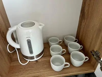a coffee maker and cups on a wooden shelf at The rainbow 3 in Sofia