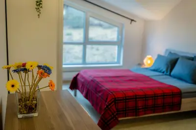 a bedroom with a bed and a vase of flowers on a table at Saint George Palace Deluxe Collection in Bansko