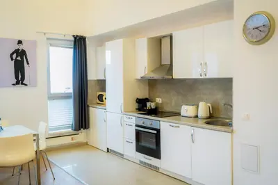 a kitchen with white cabinets and a clock on the wall at Saint George Palace Deluxe Collection in Bansko