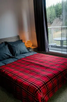 a bedroom with a bed with a red blanket and a window at Saint George Palace Deluxe Collection in Bansko
