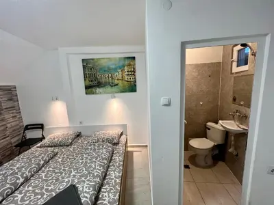 a small bedroom with a bed and a bathroom at The rainbow 1 & free motorcycle parking in Sofia