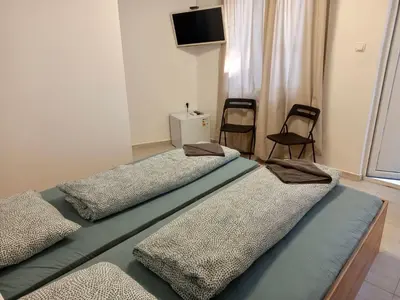two beds in a room with two chairs and a television at The rainbow 1 & free motorcycle parking in Sofia