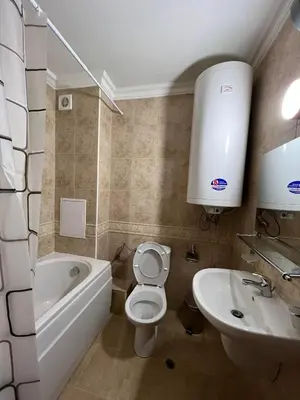 a bathroom with a white toilet and a sink at Апартамен в Манастира 3 in Smolyan