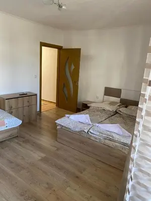 a bedroom with two beds and a wooden door at Апартамент за гости in Devin