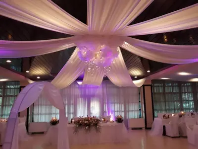 a large room with white tables and white curtains at Everest Hotel in Etropole