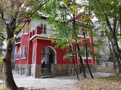 a red and white building with trees in front of it at Top Center Apartment 2 in Sofia