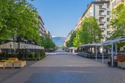 an empty street in a city with trees and buildings at Top Center Apartment 2 in Sofia