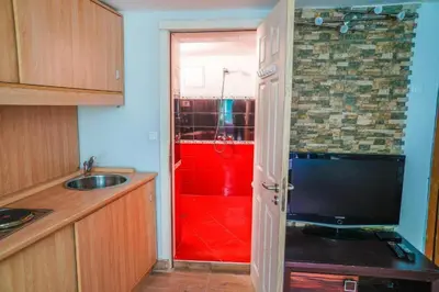 a kitchen with a red shower and a television at Top Center Studio 3 in Sofia