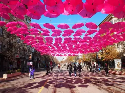 a group of pink umbrellas hanging over a street at Top Center Studio 3 in Sofia