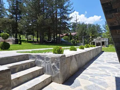 a stone retaining wall with stairs in a park at Вила Bora Vista 1 in Tsigov Chark
