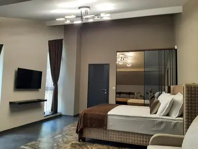 a bedroom with a large bed and a television at Вила Bora Vista 1 in Tsigov Chark