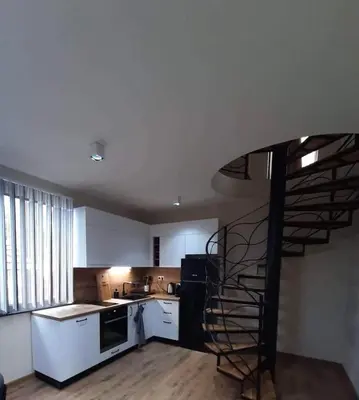 a kitchen with a spiral staircase in a room at Вила Bora Vista 2 in Tsigov Chark