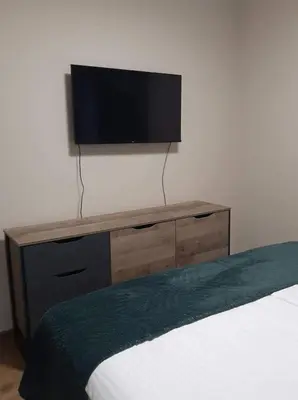 a flat screen tv on a wall above a bed at Вила Bora Vista 2 in Tsigov Chark