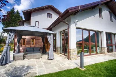 a patio with an umbrella and a house at MOUNTAIN HILL LUXURY VILLA in Madzhare