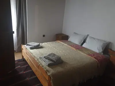 a bedroom with a bed with two trays on it at Къща за гости Близнаците in Leshten