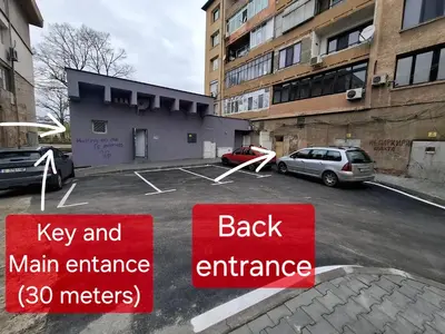 a parking lot with a back entrance and two signs at 3 Rooms Apartment, Top Center, 1st Floor Flat, AUBG, WiFi, PC i5 SSD, Tablet, AndroidMiTvBox, 3 LED TVs 200 Channels, Long Terrace, Self-Easy-Late Check-in, Stay Before Greece in Blagoevgrad