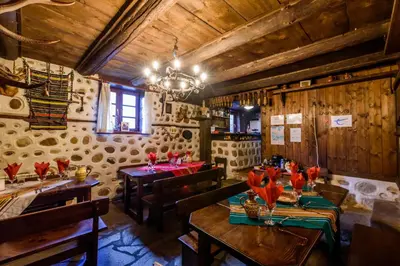 a dining room with tables and chairs and a chandelier at Chalet Mila - Total Chalets - Fully Catered in Bansko