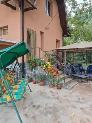 a patio with chairs and potted plants next to a building at Вила Вайлин in Batak
