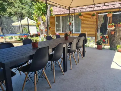 a long wooden table and chairs on a patio at Вила Вайлин in Batak