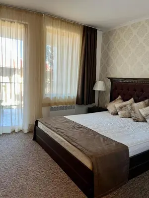 a bedroom with a large bed and a large window at Гранд Манастира частен апартамент in Pamporovo