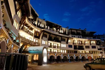 a large building with lights on it at night at Гранд Манастира частен апартамент in Pamporovo
