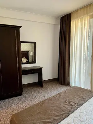 a hotel room with a bed and a mirror at Гранд Манастира частен апартамент in Pamporovo